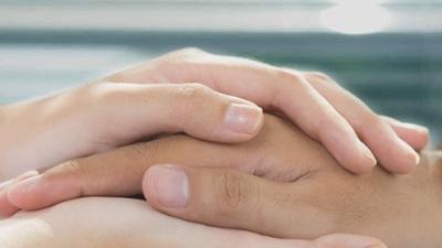 Close-up of a nurse holding patient's hand